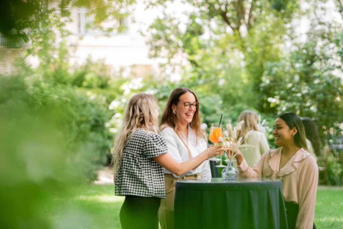a group of people having drinks in the garden of 116 Pall Mall