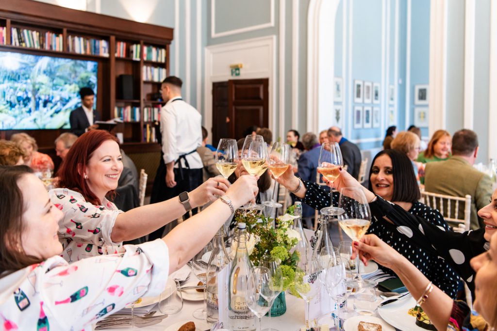 Group of people cheering with glasses of wine